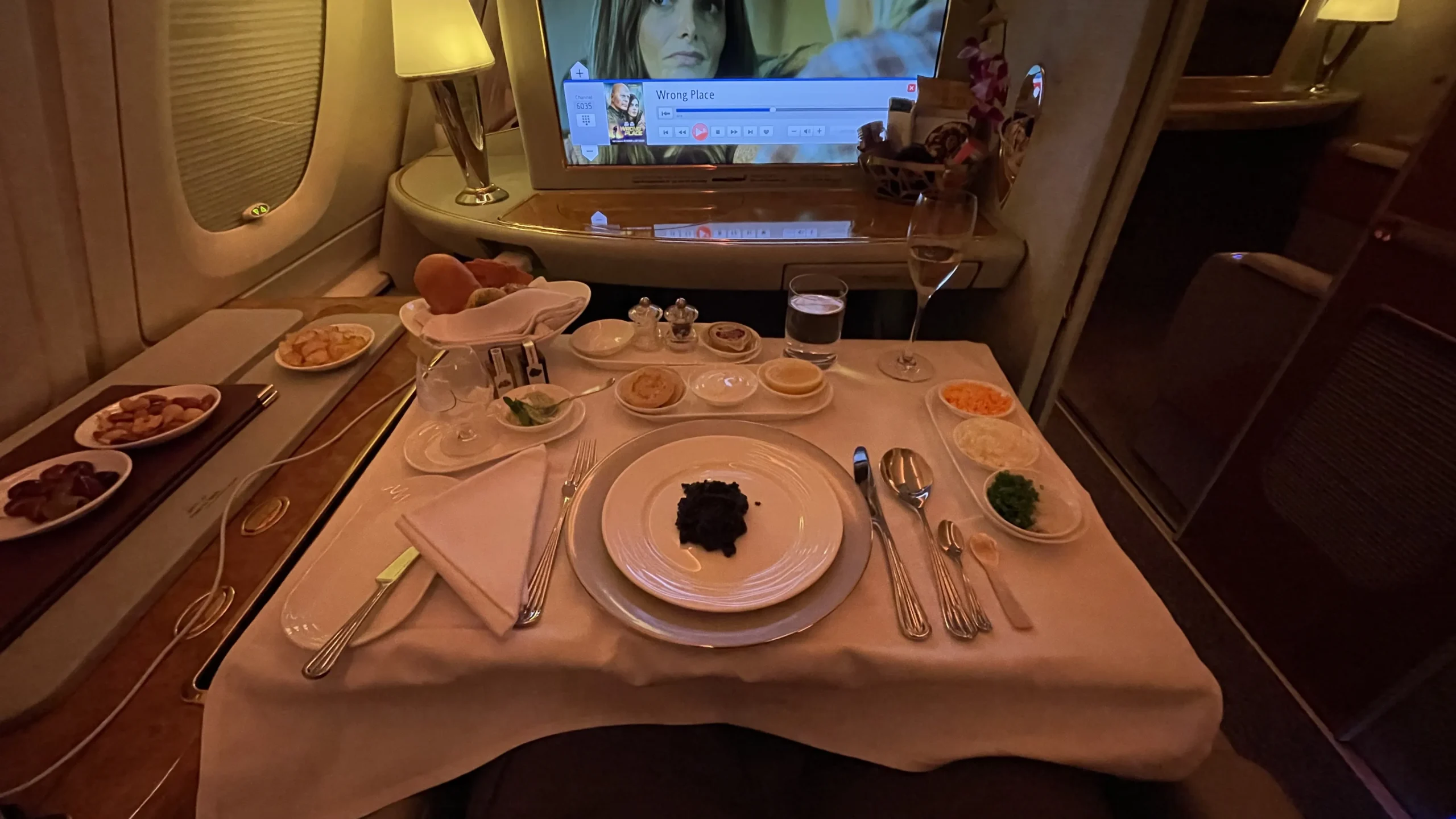 An elegant serving of caviar with traditional blinis, sour cream, and accompaniments in Emirates First Class.