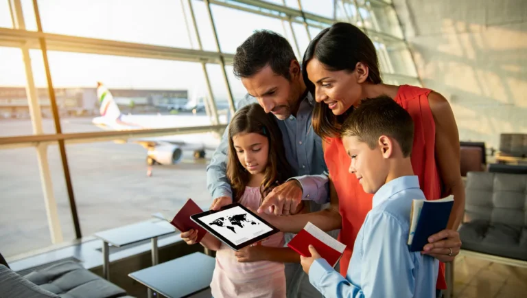 Family at airport planning their first international trip with passports and tablet map