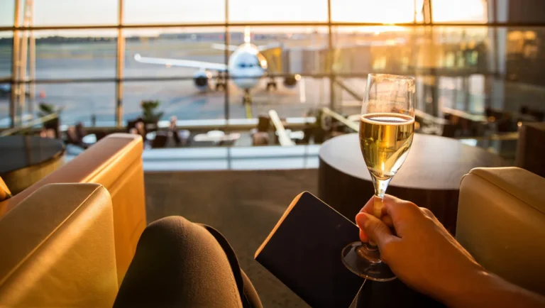 Luxury airport lounge with champagne, passport, and runway view — travel perks with best credit cards