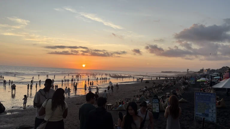 Canggu Beach in Bali during sunset, with tourists relaxing on beanbags and walking along the shore — a peaceful scene that reflects why many travelers wonder “is Bali safe” while enjoying its lively yet calm atmosphere.